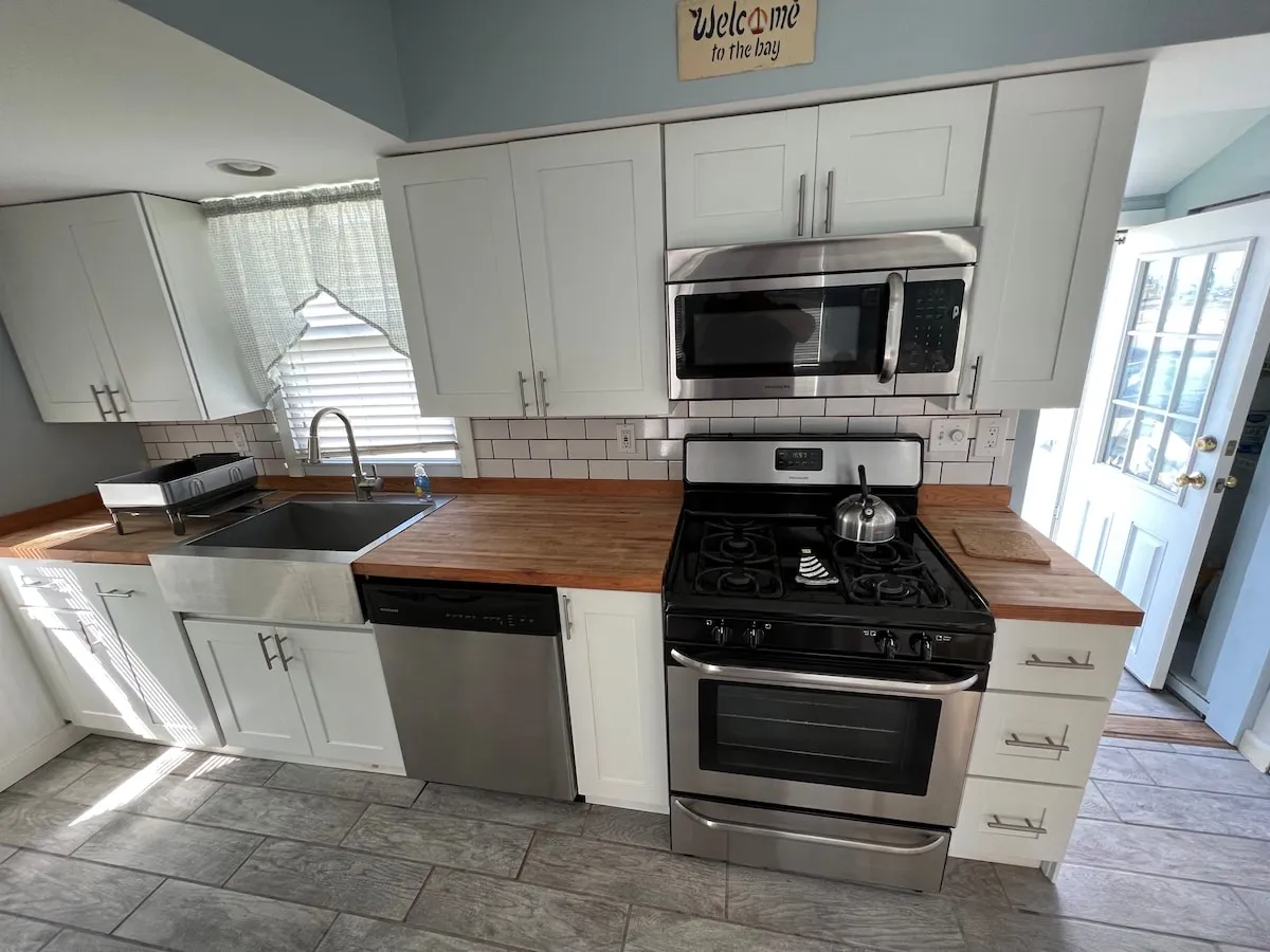 The kitchen with stainless steel stove, butcher block countertop, and window light